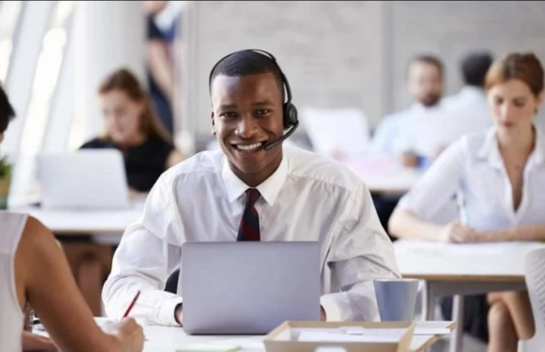 Man wearing a headset in front of a laptop