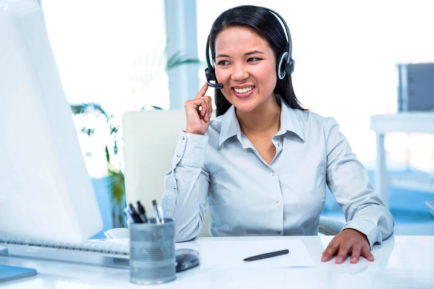 Woman wearing headset in front of a computer