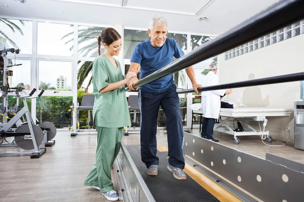 Woman helping man walking on a treadmill