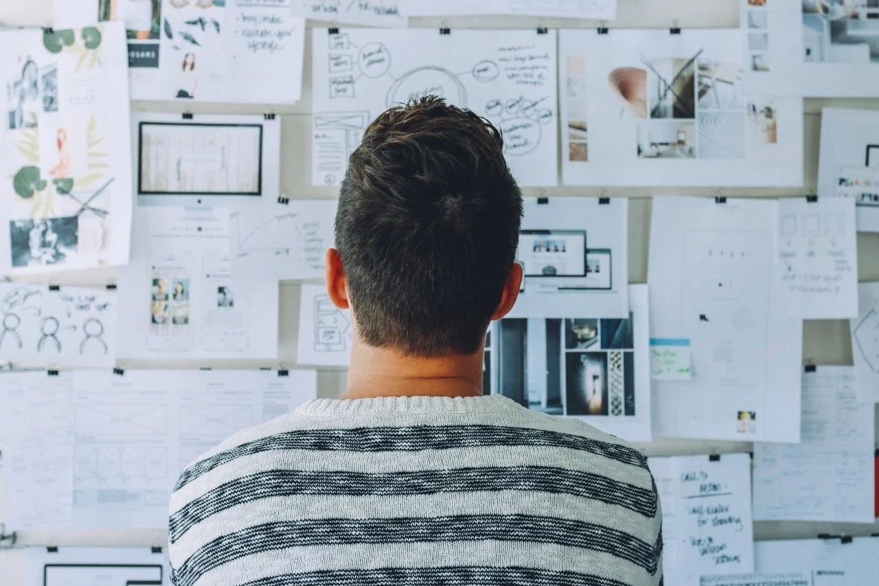 Man looking at a board full of notes