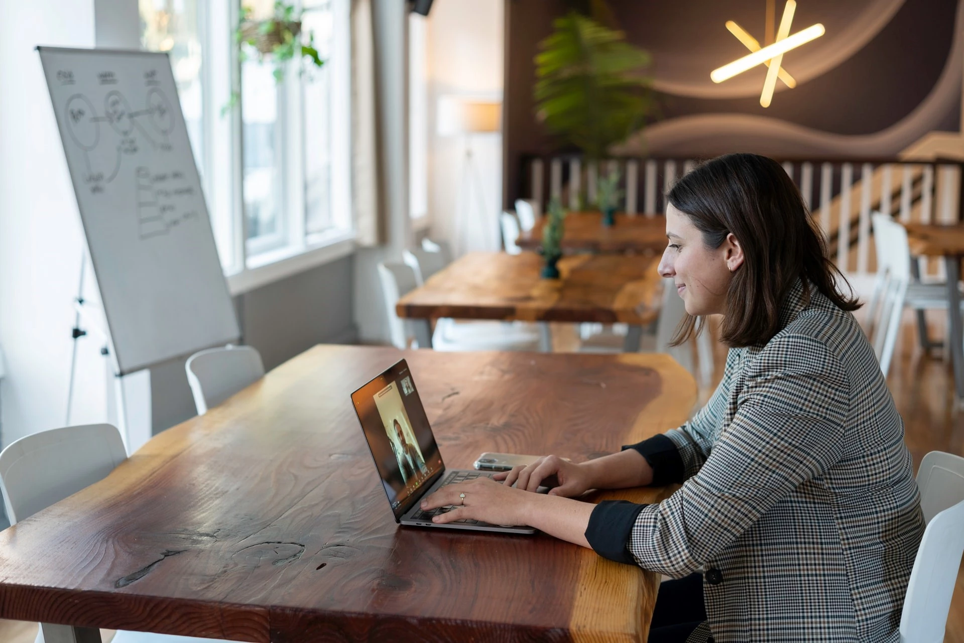 Woman wearing suit sitting at a table with a laptop