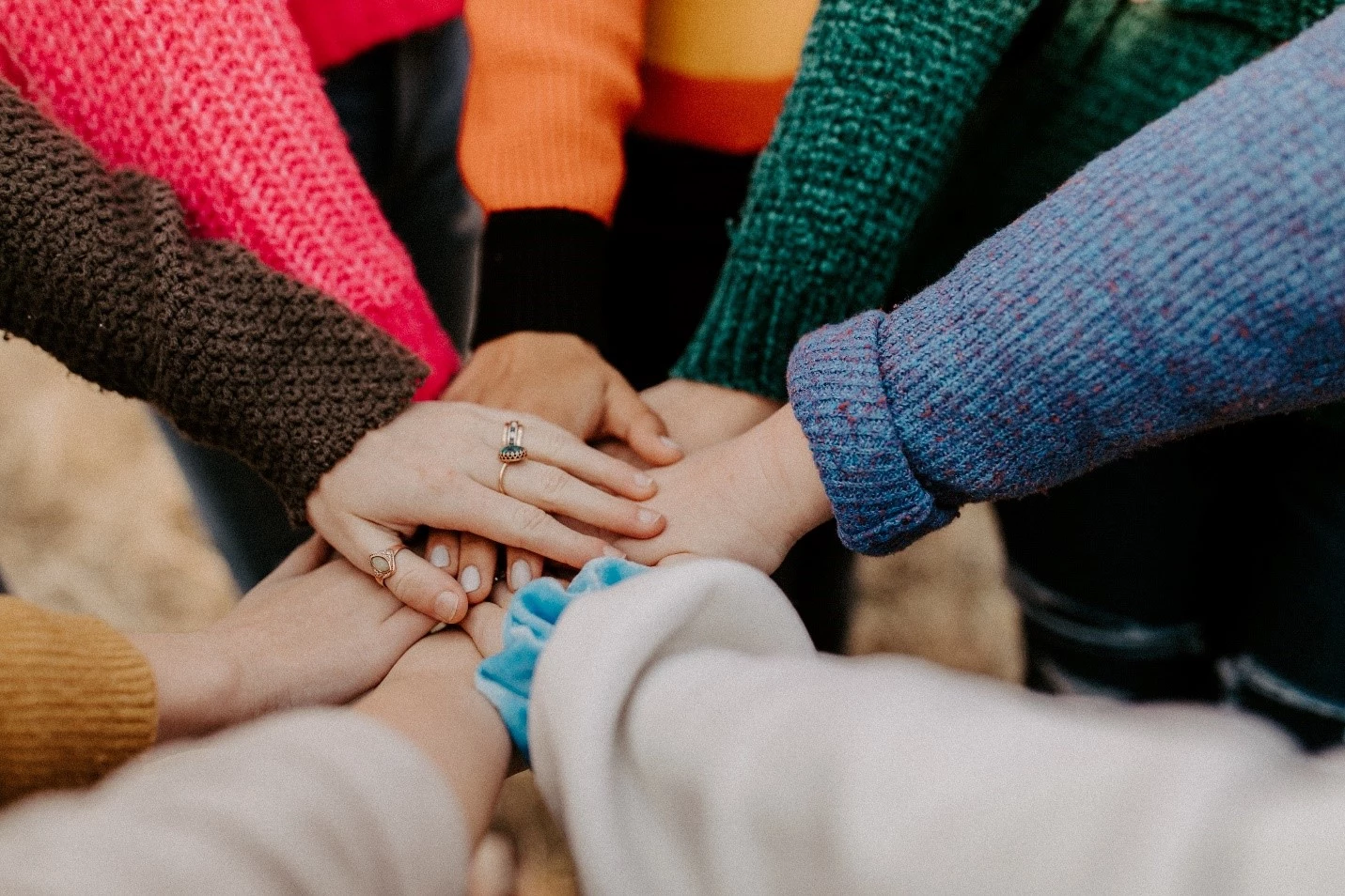 A team of people putting their hands together